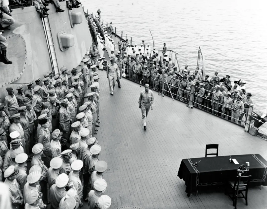 Allied leaders, including General Douglas MacArthur and Admiral William Halsey, walk past American naval and military officers gathered on board the Missouri for the September 2, 1945, surrender ceremony.