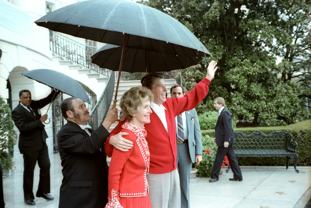 Reagan and his wife, Nancy Reagan, wave to the public as the president returns to the White House after his hospital stay.